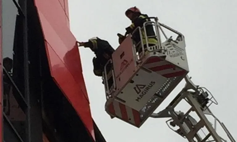 Intervenție la înălțime a pompierilor. Vântul a smuls bucăți de tablă de pe fațada unui mall